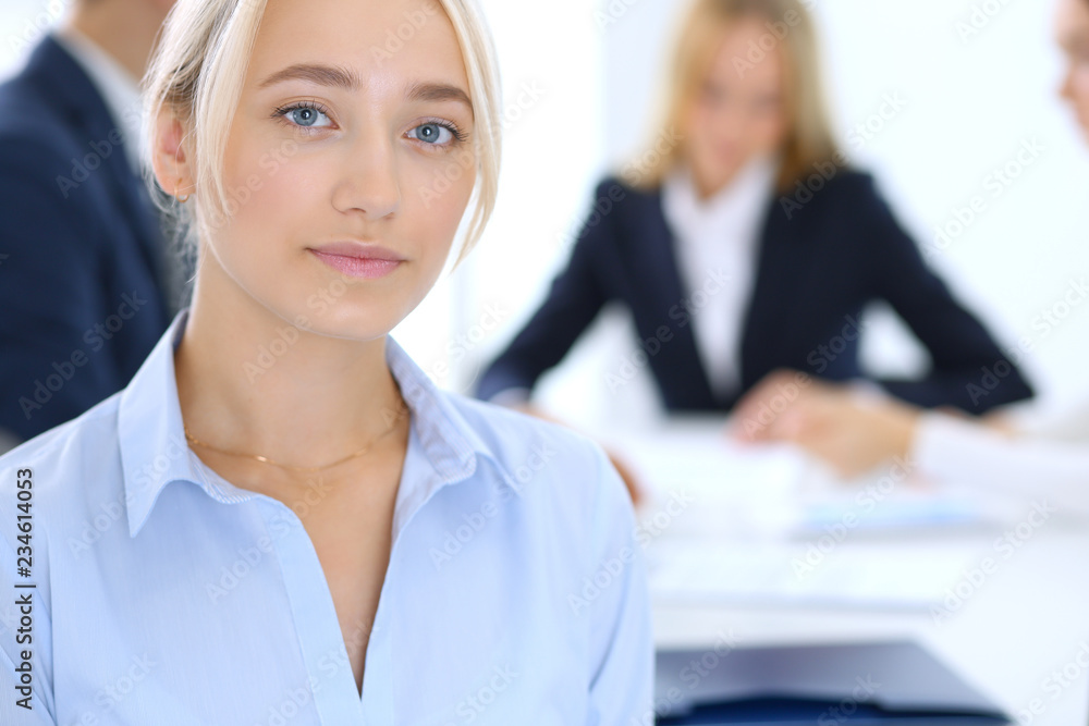 Group of business people or lawyers discussing terms of transaction in office. Focus at young business woman. Meeting and teamwork concept