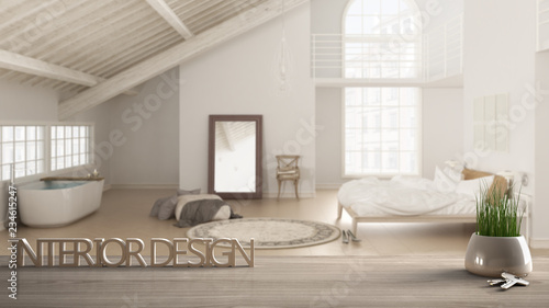 Wooden table, desk or shelf with potted grass plant, house keys and 3D letters, words interior design, over blurred loft with bedroom and bathroom, project concept copy space background photo