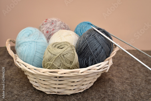 Knitting accessories in the basket on the woolen background  