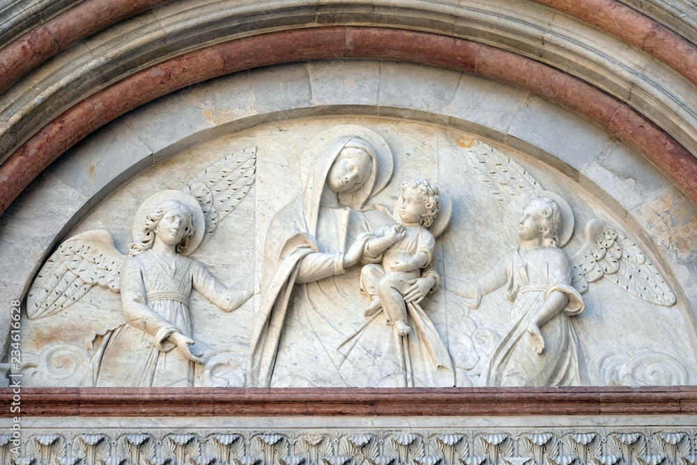 Bass relief representing the Virgin Mary with baby Jesus between angels, Cathedral of S. Martino in Lucca, Tuscany, Italy 