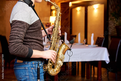Photography The musician plays the saxophone in the evening in a cozy restaurant