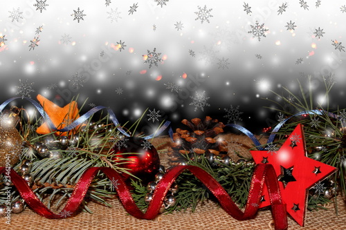 красивый новогодний фон с елочными игрушками и веточками ели на фоне падающих снежинок 