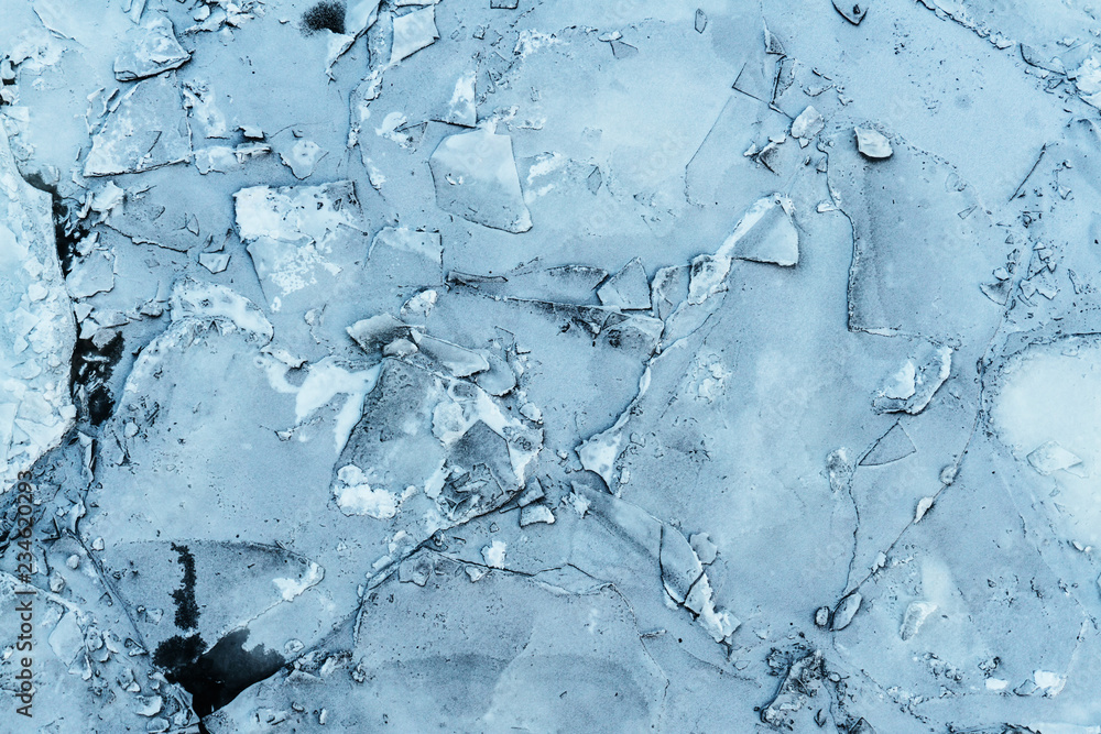 texture of cracked frozen ice on a natural pond on a winter cold day texture of cracked frozen ice on a natural pond on a winter cold day