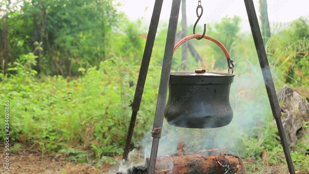 Cooking on fire in cast iron cauldron slider shoot. Cooking soup with meat and potatoes in cast iron cauldron Cooking on fire in cast iron cauldron slider shoot. Cooking soup with meat and potatoes in cast iron cauldron