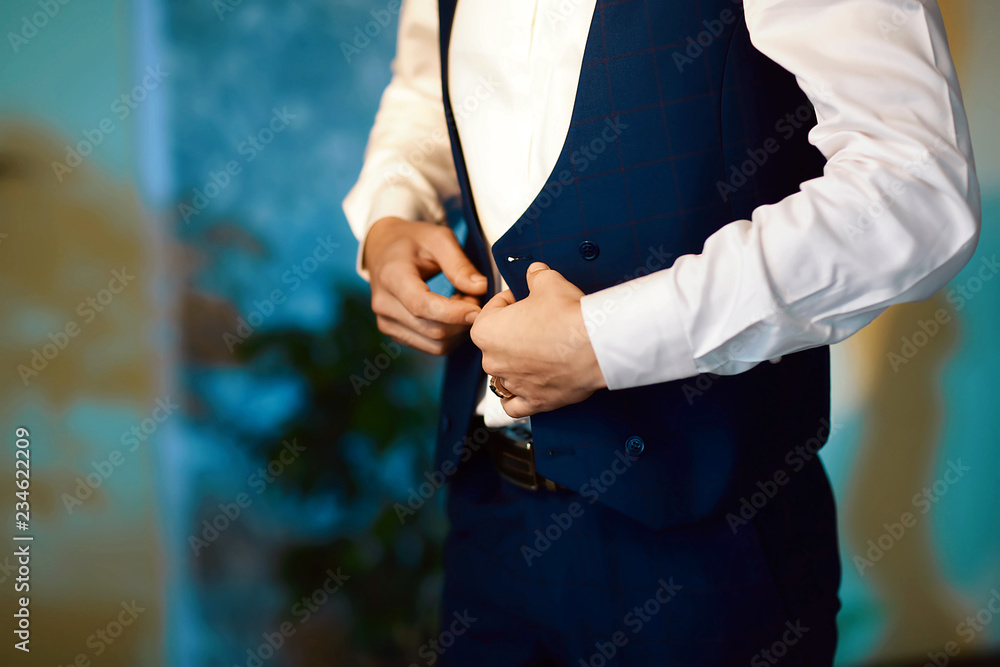 Grooms morning preparation, handsome groom getting dressed and preparing for the wedding, the jacket is laid