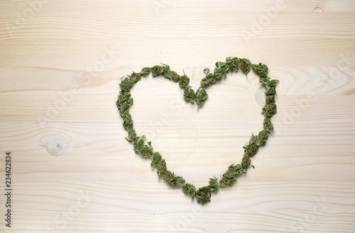 Medical marijuana concept with dry cannabis bud on a wooden background.