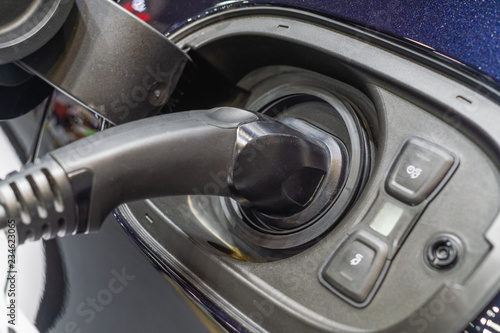 Close up image of an electric car is being charged at a charging station © ezstudiophoto