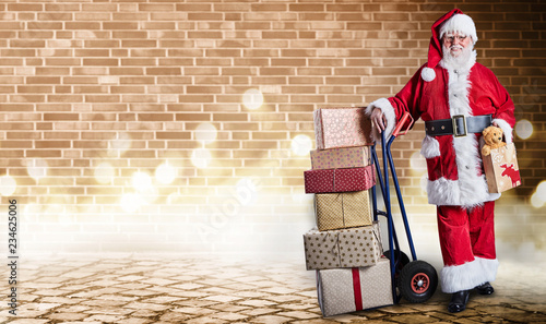 Santa with presents on trolley in festive lighting photo