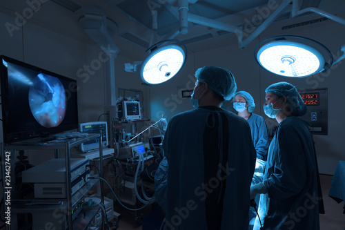 group of veterinarian surgery in operation room for laparoscopic take with art lighting and blue filter photo