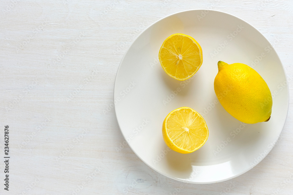 Lemon cut in half on plate with white copy space Lemon cut in half on plate with white copy space