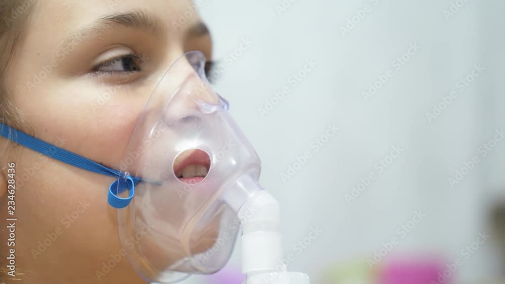 Teen's face inhaling through inhaler mask Teen's face inhaling through inhaler mask
