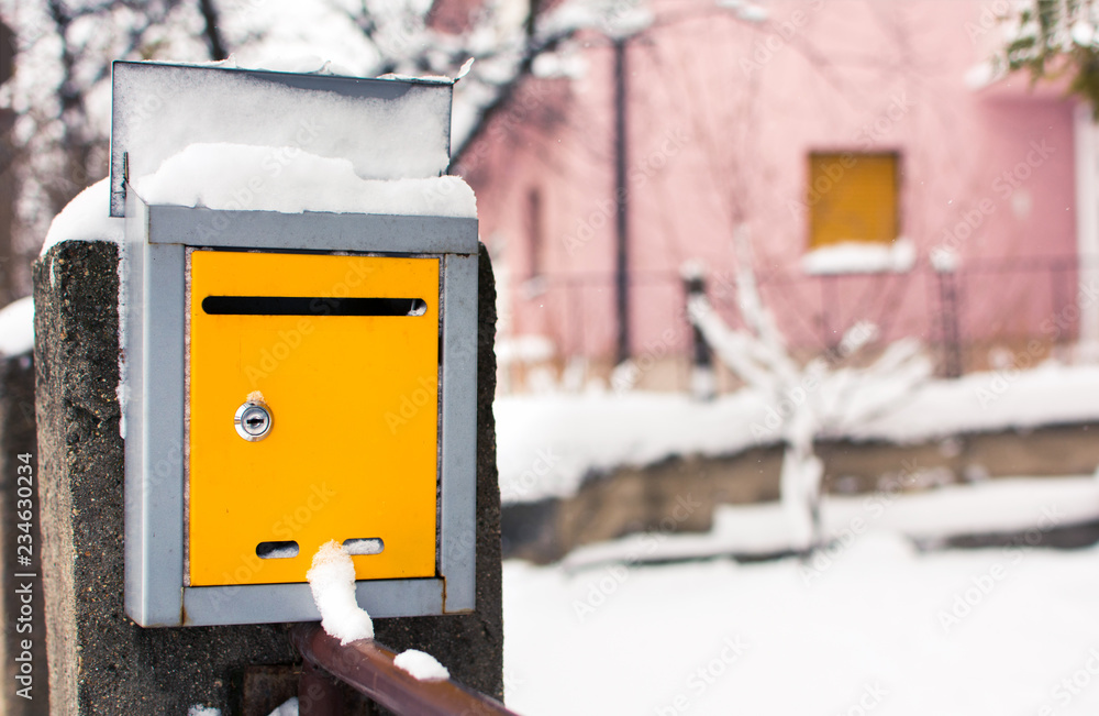 Snow covered mailbox in front of a house Snow covered mailbox in front of a house