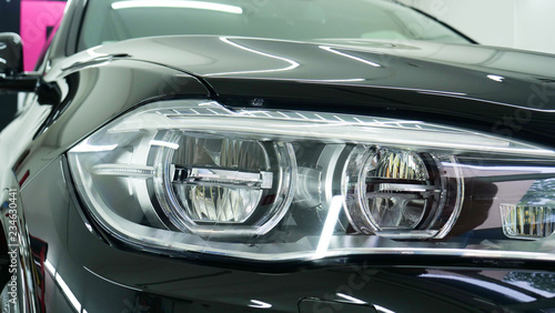 After professional polishing, ceramics and car washes show headlights on new cars. Concept of: Auto Service, Different Colors, Car wash, Presentation, Glittering Headlights.