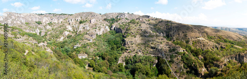 Panorama beautiful canyon at Khndzoresk cave settlement (13th-century, used to be inhabited till the 1950s) with a suspension bridge underneath, Syunik region, Armenia