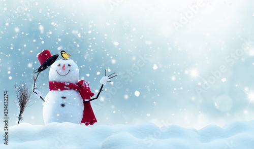 Merry christmas and happy new year greeting card with copy-space.Happy snowman standing in winter christmas landscape.Snow background © Lilya