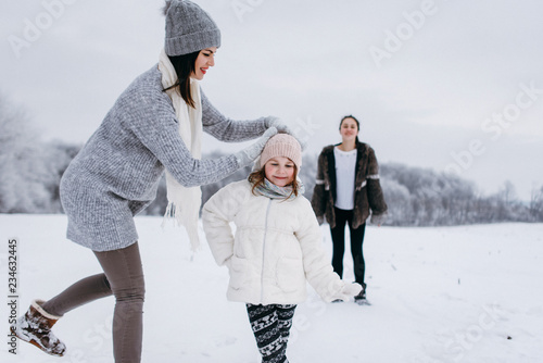 Happy family. Mother and child daughters on a winter walk outdoors. 