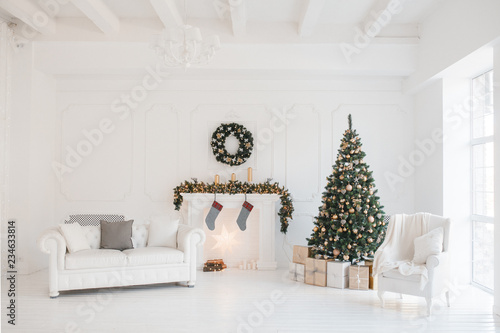Christmas and New Year decorated white interior room with presents and New year tree and fireplace
