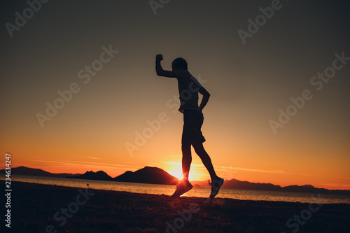 Young energetic happy man jumping on the seashore
