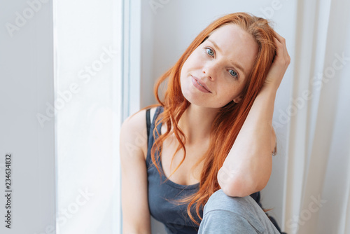 Thoughtful young blue-eyed woman