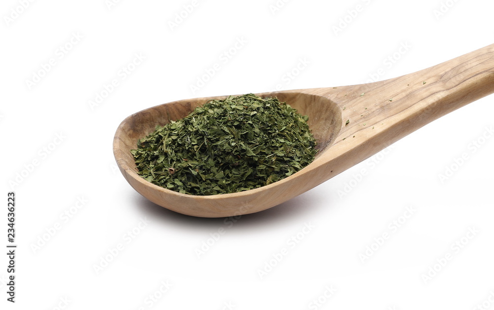 Chopped dry parsley leaves, pile with wooden spoon isolated on white background Chopped dry parsley leaves, pile with wooden spoon isolated on white background