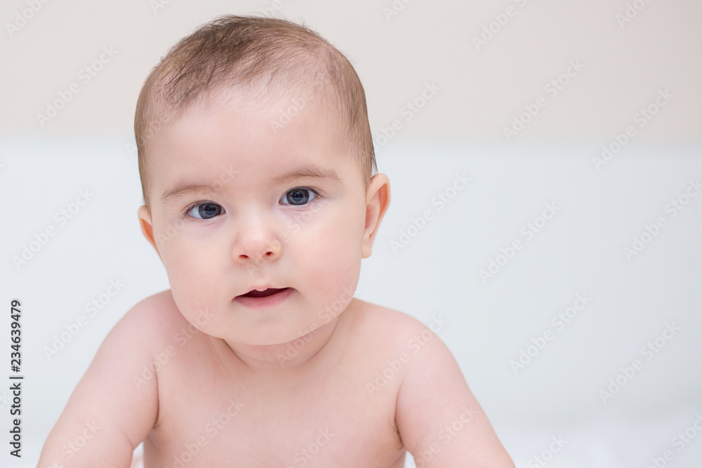 Little cute baby is crawling on a white bed Little cute baby is crawling on a white bed