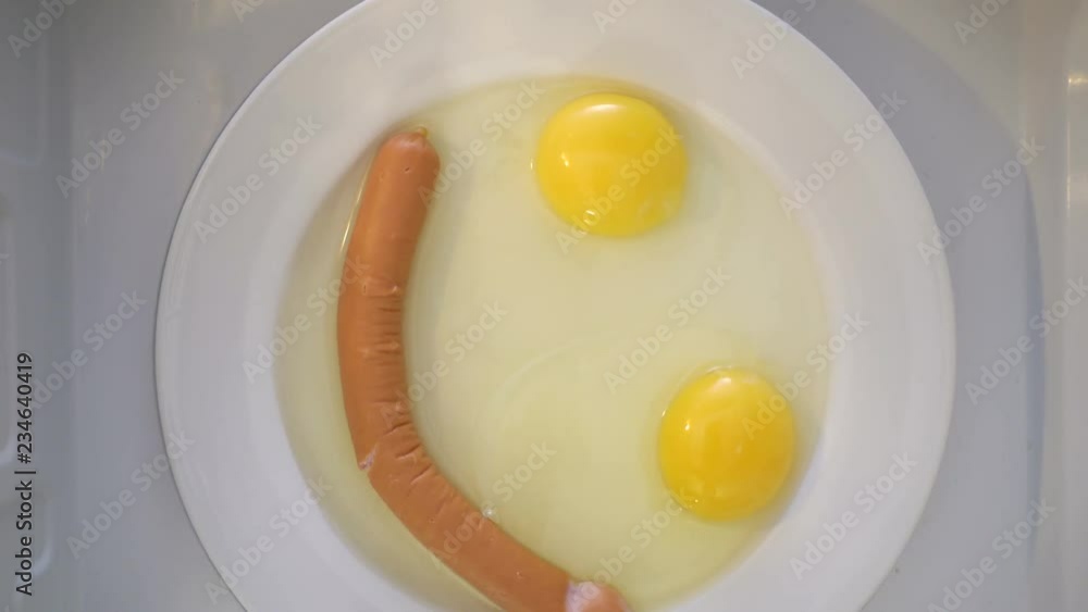 Making microwave breakfast meal. Smiling face of fried eggs and sausage Making microwave breakfast meal. Smiling face of fried eggs and sausage