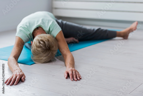 Active senior woman practicing yoga indoors. Exercise for Older Adults