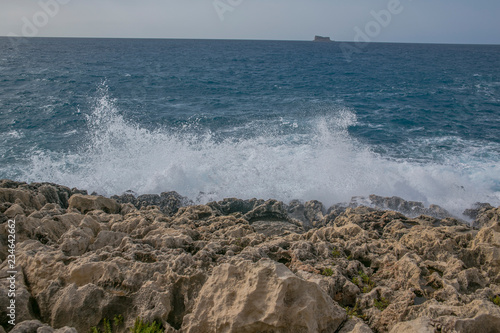 Sea waves splashing on rocky shore, marine background	