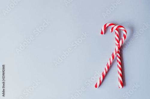 Two cane candies on a gray background.