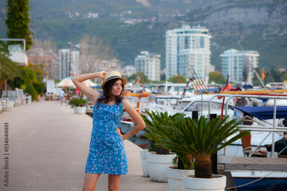 Europe summer travel mediterranean destination. Tourist woman on vacation, walking on the marina of old Mediterranean city. Budva, Montenegro