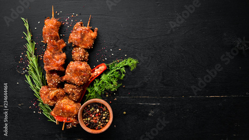 Skewers of barbecue sauce. On a wooden background. Top view. Free space for your text.