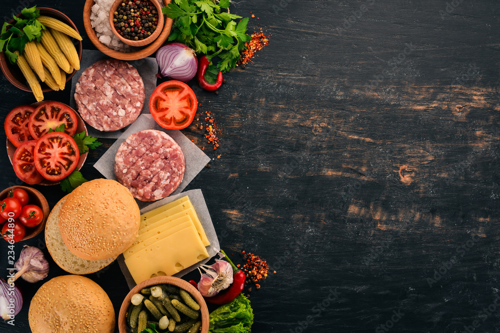 Raw burger Cooking a burger with meat. On a black wooden background. Top view. Free copy space. Raw burger Cooking a burger with meat. On a black wooden background. Top view. Free copy space.