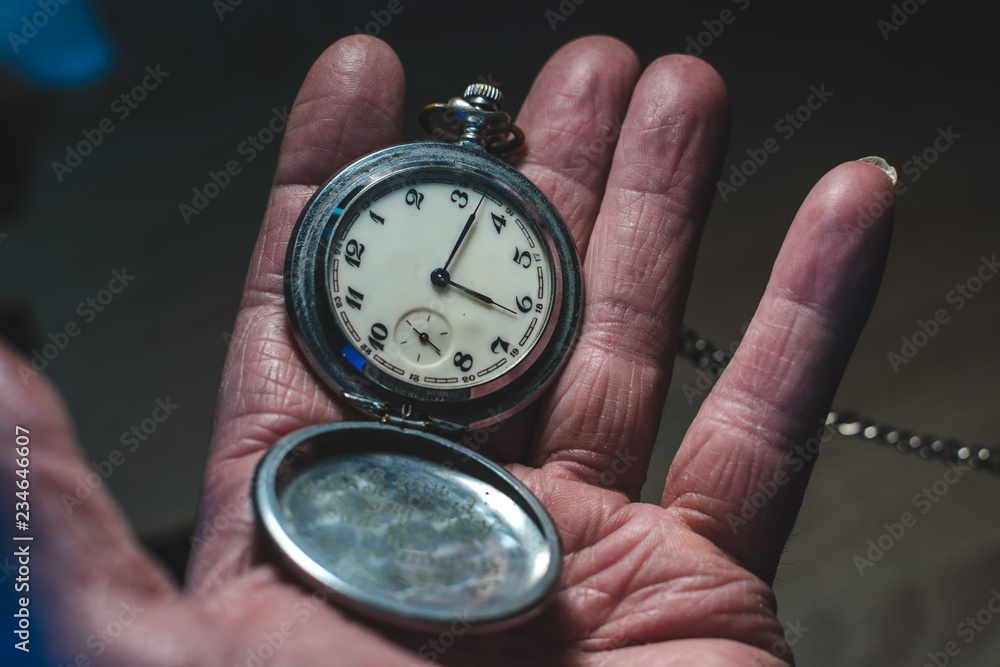 old man holds in his hand a retro pocket watch on a chain, the concept of a bygone time and old age old man holds in his hand a retro pocket watch on a chain, the concept of a bygone time and old age