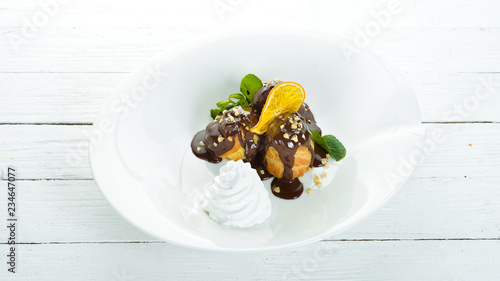 Pastry with chocolate and cream. On a wooden background. Top view. Free copy space.