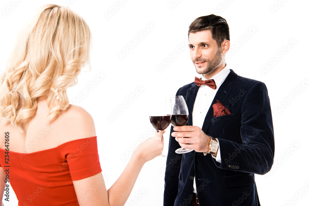Back view of woman in beautiful red dress and man with glasses of red wine isolated on white Back view of woman in beautiful red dress and man with glasses of red wine isolated on white