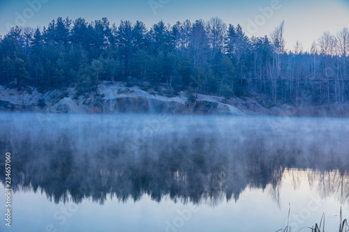 Early misty morning. Dawn over the lake with the rocky shore