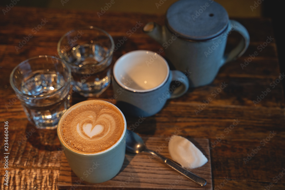 Two cups of coffee and a glass of water on rustic wooden table. Close-up Two cups of coffee and a glass of water on rustic wooden table. Close-up