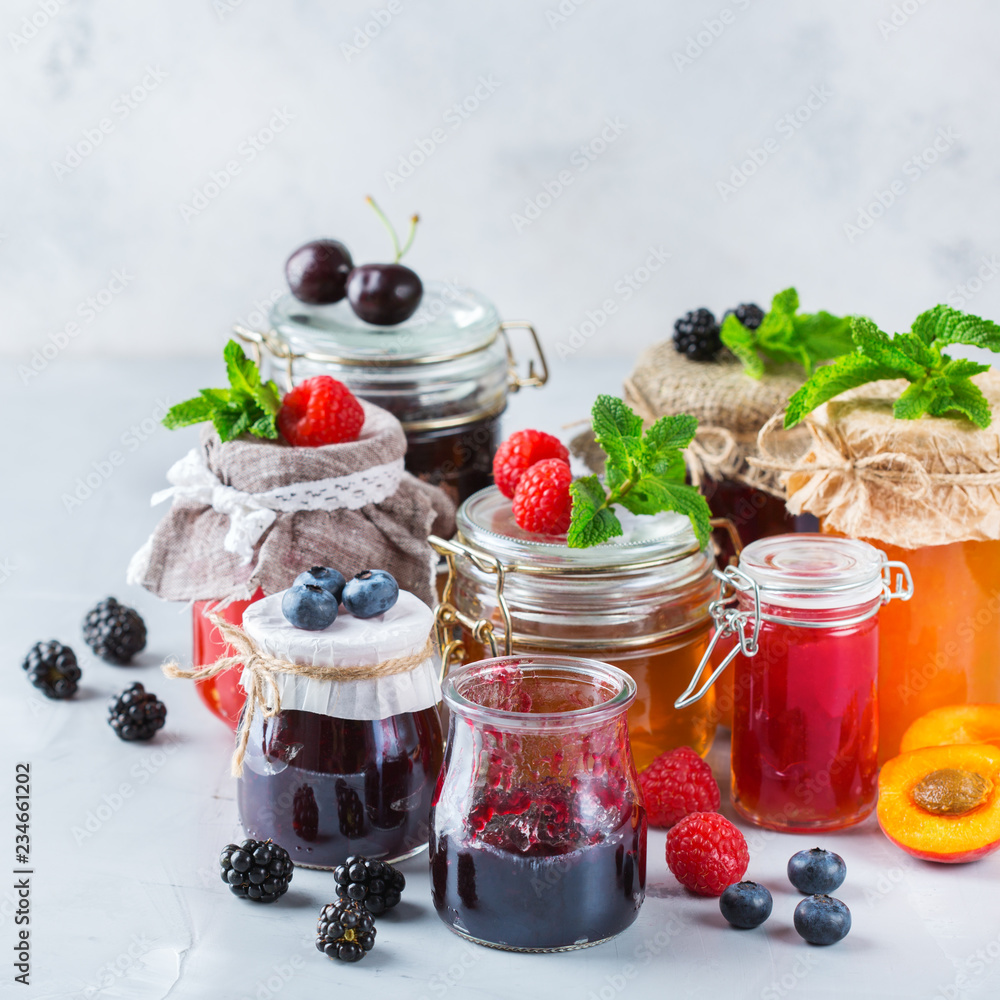 Assortment of seasonal berries and fruits jams in jars Assortment of seasonal berries and fruits jams in jars
