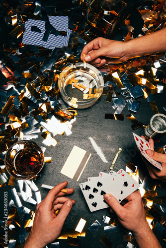 Photography partial view of men playing poker with cocaine, alcohol and cigarettes at table