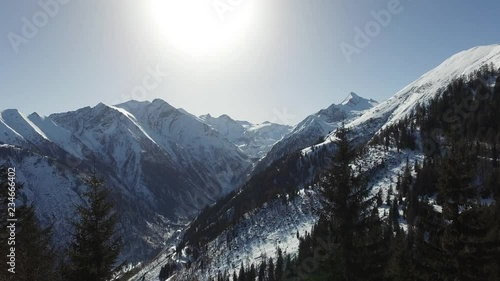 Pan across Snow covered mountain valley in the sunshine