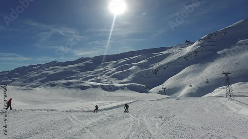 Snowboarding down piste sunny day