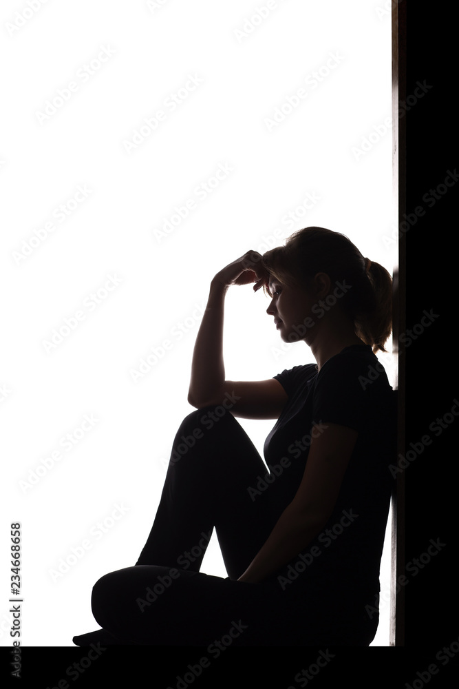 silhouette of a woman sitting on the floor in a corner on a white isolated  background, a sad girl thinking about problems, concept of depression Stock  Photo | Adobe Stock