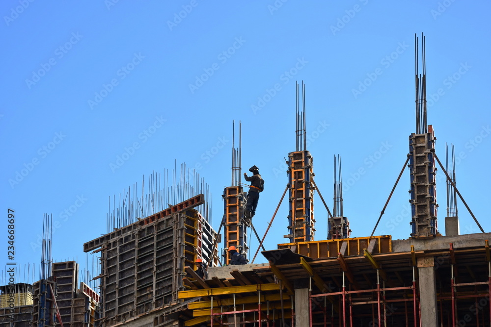 The process of building a modern high-rise house. Monolitno-frame building. Building construction. Construction site with workers. The process of building a modern high-rise house. Monolitno-frame building. Building construction. Construction site with workers.