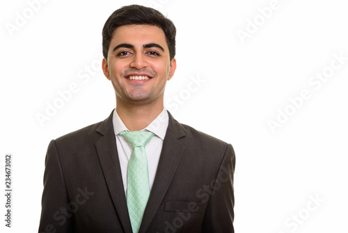 Young happy Persian businessman looking at camera