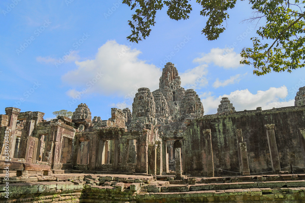 Ancient temple name Bayon with stone faces in Angkor Thom, Siem Reap, Cambodia. Bayon's most distinctive feature is the multitude of serene and smiling stone faces on the many towers.