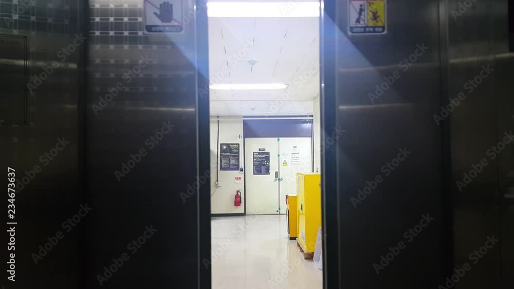 4K view of opening elevator door towards a narrow corridor in a modern building 4K view of opening elevator door towards a narrow corridor in a modern building