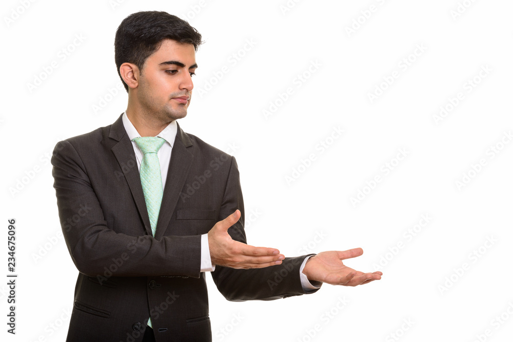 Portrait of young handsome Persian businessman showing something Portrait of young handsome Persian businessman showing something