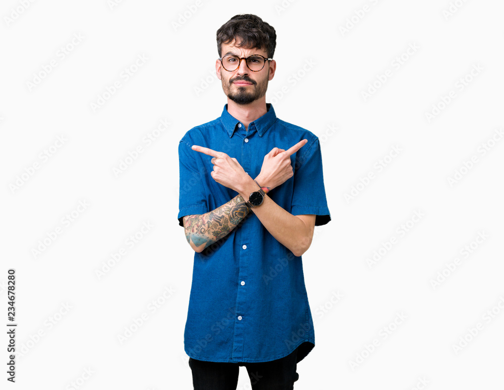 Young handsome man wearing glasses over isolated background Pointing to both sides with fingers, different direction disagree Young handsome man wearing glasses over isolated background Pointing to both sides with fingers, different direction disagree