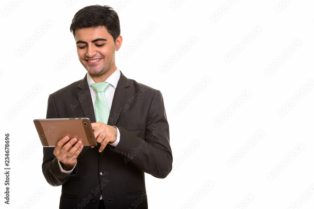 Young happy Persian businessman using digital tablet Young happy Persian businessman using digital tablet