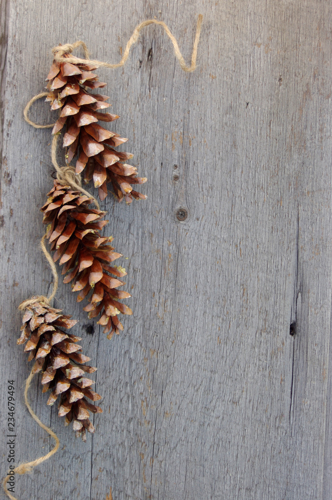 three pinecones with twine ribbon on rustic wooden background with copy space three pinecones with twine ribbon on rustic wooden background with copy space